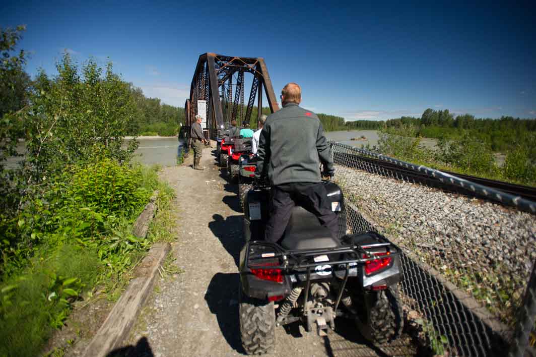 Quads starting across the railroad bridge